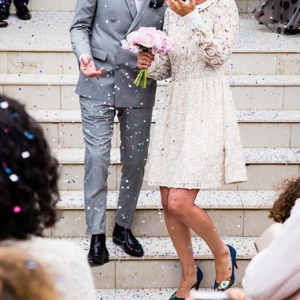 A Professional Photographer's Guide to Wedding Attire As a wedding photographer, you carry a unique responsibility: to capture the essence of one of the most significant days in a couple's life. While your primary focus is on taking stunning photographs, your attire plays a crucial role not just in your efficiency and comfort, but also in how seamlessly you blend into the event. Here is a brief guide from Emma Seaney Photography on what to wear when photographing weddings, ensuring you look professional yet prepared for every possible scenario. Comfort Over Style: The Foundation of Your Wedding Day Ensemble First and foremost, prioritise comfort over style. Weddings are typically lengthy affairs, often stretching from early morning preparations to late evening celebrations. As a photographer, you will be moving around constantly, often standing for prolonged periods. Wearing comfortable clothing helps you maintain your stamina and focus throughout this marathon of a day. The Importance of Comfortable Footwear One of the most critical aspects of your outfit is your footwear. Opt for shoes (or smart trainers) that are not only stylish, but supremely comfortable. Blisters, or sore feet, are more than just physical irritants; they can distract you and detract from your mental focus, potentially affecting your performance. If you discover a pair of shoes that meets all these criteria and you plan to shoot weddings regularly, consider purchasing several identical pairs. Having backups is practical, especially when one pair begins to wear out. Dress to Blend In Your outfit should be discreet enough to ensure you blend in with the guests. This is especially important, as you don’t want to stand out in any candid shots captured by attendees. Typically, something understated yet elegant – akin to what you might wear to a business conference or a semi-formal dinner – works best. This approach also respects the event's decorum, aligning with the general ambience. Colour Scheme Coordination If the wedding invitation or your communication with the client specifies a colour scheme, dressing in hues that match or complement, it can be a thoughtful and professional touch. This attention to detail shows respect and consideration for the event's theme, further integrating you into the wedding’s atmosphere. Practical Considerations for Clothing Avoid clothing that carries the branding of your photography business. While branded attire is excellent for commercial and promotional events, it can seem out of place at a wedding. Opt instead for neutral, unbranded clothing that keeps the focus on your professionalism and discretion. Even though expensive suits and designer dresses might be tempting, remember you need attire that allows for a considerable range of motion. Wedding photographers often find themselves crouching, kneeling, or even lying on the ground to capture the perfect angle. Therefore, select outfits that are both smart and flexible. Preparing for All Weather Conditions Always have a backup outfit (or several) and additional items suitable for varying weather conditions readily available. Conditions can change swiftly; sunny mornings can turn into rainy afternoons. Having alternatives for hot, cold, and wet weather will ensure that you're comfortable and your performance remains unaffected. An extra set of clothes can also be a lifesaver in case of accidental spills or getting caught in the rain (or snow). Gear and Accessories If you are someone who uses two cameras simultaneously, consider investing in a camera body harness. This accessory will not only ease switching between cameras, but will also help distribute the weight more evenly, reducing strain during long shooting sessions. Protecting Yourself Against the Elements Never underestimate the importance of suncream and a pair of high-quality sunglasses. Even when you are not behind the lens, protecting your skin and eyes from sun exposure is critical. Choose sunglasses that can be easily removed or placed in a secure pocket. The Photographer’s Personal Kit Emma highly recommends creating your own “personal kit” box that contains essentials you might need throughout the day. This kit could include headache tablets, a first aid kit, a water bottle or an energy drink, snacks to keep your energy up, extra batteries (battery back) and chargers (beyond what you take for your camera gear), sowing kit, safety-pins, tape, scissors, hair-clips and even spare socks. Having these items on hand can help you manage minor inconveniences and maintain your focus on capturing beautiful moments. The Smart, Agile Wedding Photographer Your attire as a wedding photographer is a crucial aspect of your professional presence at these important occasions. It should enhance your ability to perform at your best, reflect respect for the event, and equip you with what you need to face a long day of work. By paying attention to both comfort and appropriateness, ensuring flexibility and preparedness for any weather situation, and considering the practical aspects of your clothing choices, you can ensure that your only concern is capturing the moments that matter. Armed with this guidance, you can approach wedding photography with confidence, knowing that you are dressed to excel both behind the camera and in interacting with wedding guests. Remember, the right outfit not only aids in your professional duties but also underscores your role as a key contributor to the success of the day.